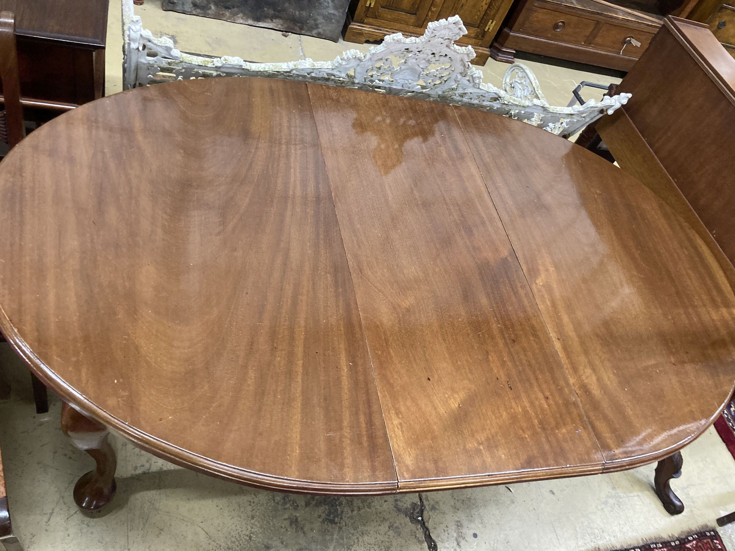 A 1930s mahogany oval topped extending dining table, one spare leaf, 174cm extended, width 106cm, height 73cm and winder